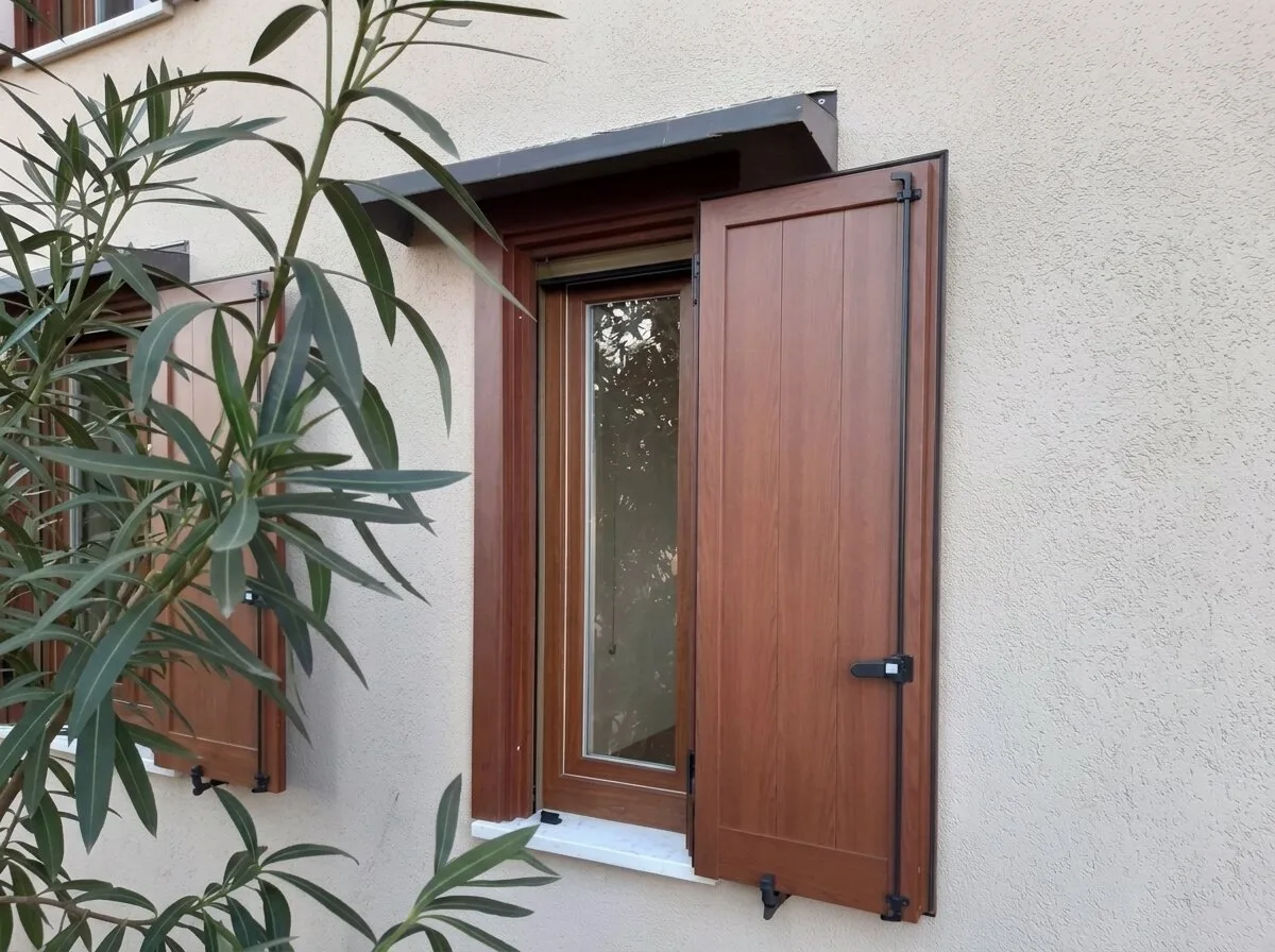 Finestra con antone in alluminio effetto legno aperto sulla facciata di una casa