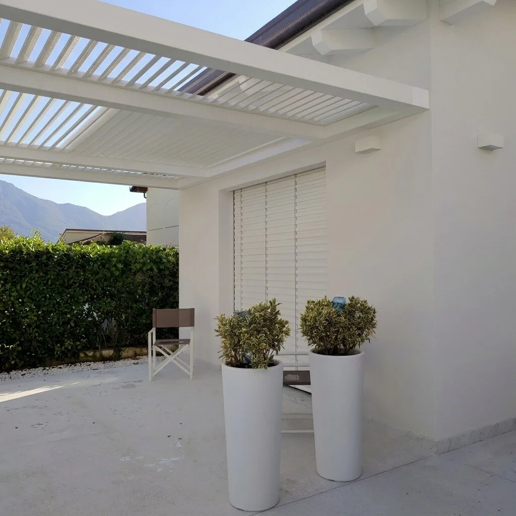 Pergola con lamelle frangisole bianche sopra una terrazza